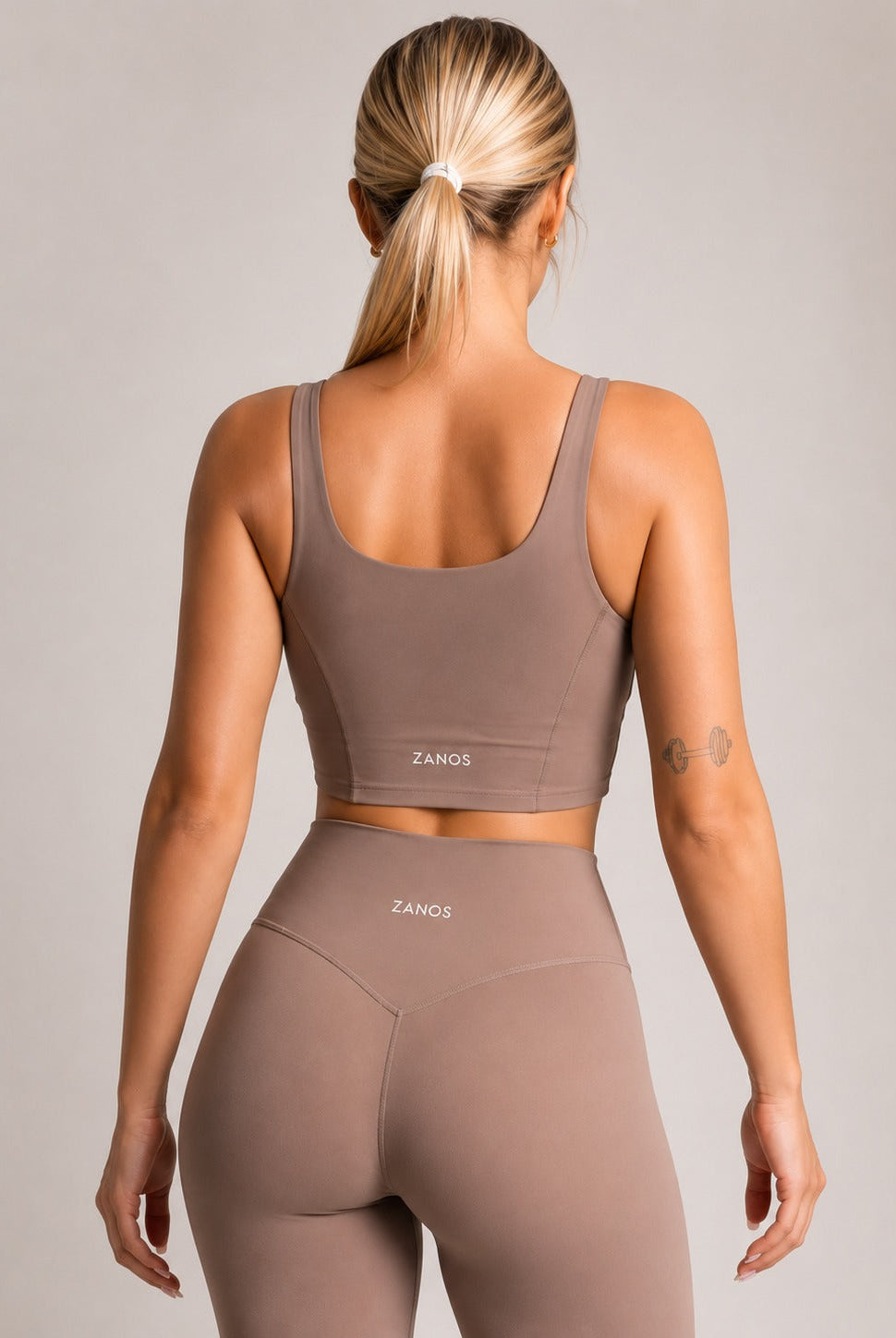 Woman wearing stylish yoga leggings and crop top showcasing best yoga leggings for women in a neutral color.