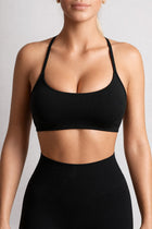 Person wearing a black sports bra and leggings on a light gray background