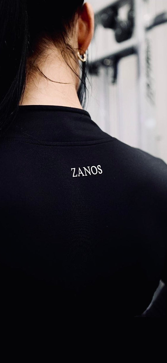 Person wearing a black shirt with 'ZANOS' branding, facing away from the camera.