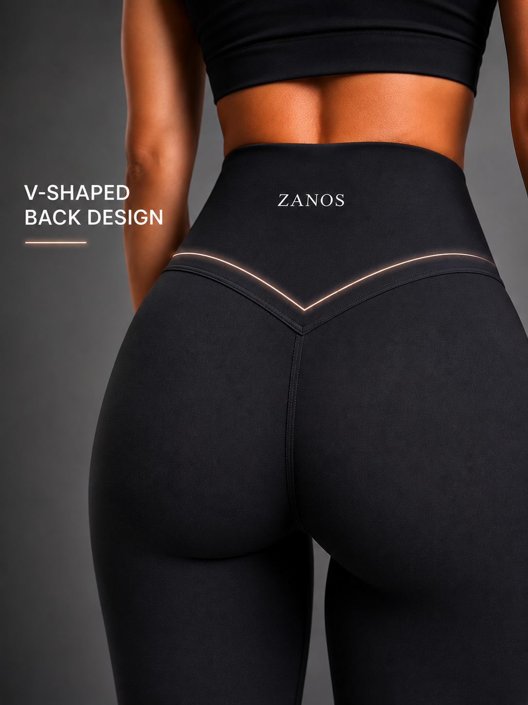 Close-up back view of a model wearing black high-waisted leggings with a V-shaped waistband design and the brand name ZANOS printed in white. Text on the left reads 'V-SHAPED BACK DESIGN'.